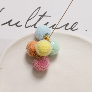 Colorful sequin pom-pom charms for DIY jewelry making on white display tray