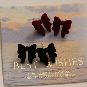 Détail de boucles d'oreilles nœuds floqués rouges et noirs sur carte décorative