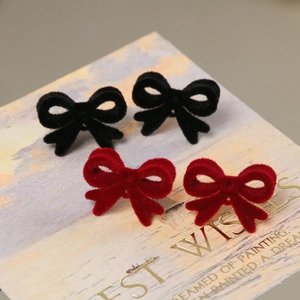 Boucles d'oreilles nœuds vintage floqués en noir et bordeaux sur carte décorative