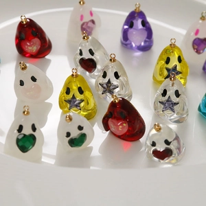 Macro shot of colorful resin ghost charms with glitter hearts and stars for DIY jewelry