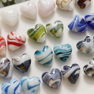 Macro detail of heart-shaped glass beads with marble texture for DIY jewelry making