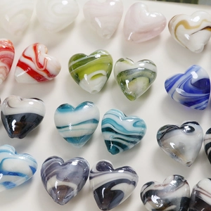 Macro shot of colorful marble patterned heart beads for handmade jewelry DIY crafts