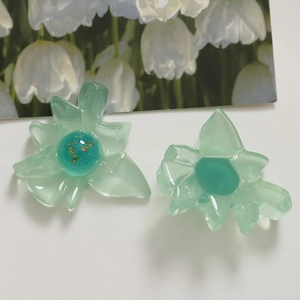 Nahaufnahme der durchscheinenden grünen Harzblumen mit Goldfolie für DIY-Schmuckzubehör