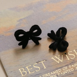 Vue macro de boucles d'oreilles nœud en velours noir avec tiges en argent S925