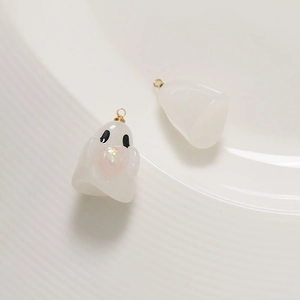 Detailed view of cute resin ghost charms holding a pink glitter heart with gold rings