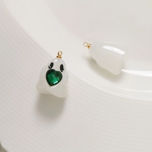 Detailed view of translucent ghost charms with green hearts and gold metal loops