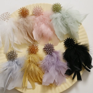 Macro detail of assorted feather tassel beads in pink white and grey for DIY jewelry making