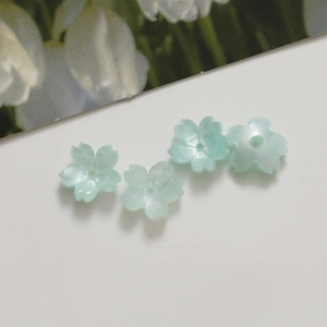 Close-up of 12mm mint green translucent acrylic flower beads for DIY jewelry making
