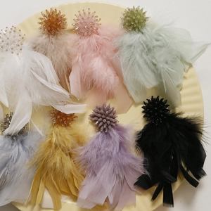 Close-up of colorful feather tassel DIY earring accessories with beaded flower tops