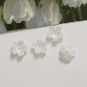 Detailed view of translucent white 12mm flower acrylic beads with center holes for DIY jewelry