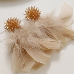 Detailed close-up of pink feather tassel earrings with handmade bead flower clusters