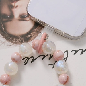Pink marble and pearl bead phone lanyard with transparent gasket on fashion magazine