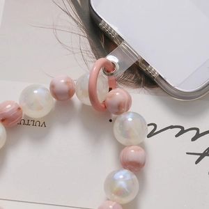 Detail of pink marble and pearlescent beads with metal ring on clear phone case