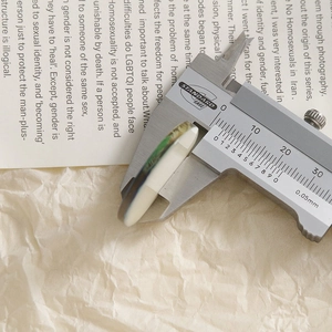 Digital caliper measuring the 5mm thickness of a round sunflower resin flower pendant