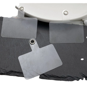 Three clear PVC phone lanyard tether pads with reinforced metal loops on a dark stone base