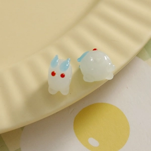 Vue macro de perles de lapin blanc en verre pour bijoux DIY sur une assiette jaune