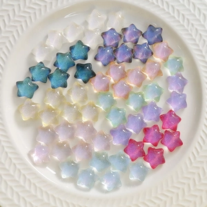 Kleurrijke hars sterbedeltjes met iriserende glitters in witte keramische schaal