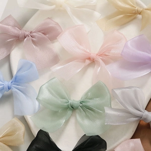 Schattige tule strik haaraccessoires in diverse pastelkleuren op een wit dienblad