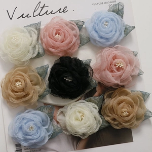 Close-up of mesh rose flower accessories with pearl centers and mesh leaves