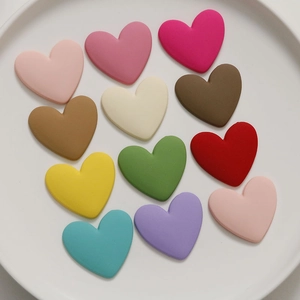 Flat lay of colorful matte resin heart charms for DIY hair accessories and jewelry making