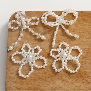 Detalle de dijes de flores y lazos de perlas tejidas a mano para accesorios de joyería DIY