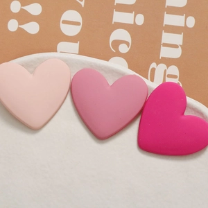 Detailed view of three heart-shaped resin charms in gradient pink with matte finish