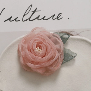 Elegant layered pink mesh camellia flower accessory with green leaves and white stamens