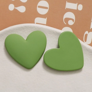Close-up of matte avocado green heart-shaped resin charms for DIY jewelry making