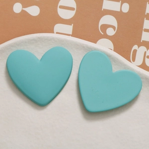Macro view of matte turquoise heart-shaped resin charms with smooth frosted texture