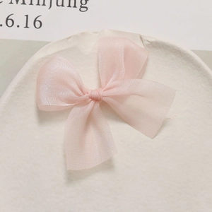 Detail van een zachte roze strik van mesh op een wit keramisch bordje