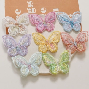 Vue macro de huit écussons papillons brodés colorés avec détails fins en tissu de maille