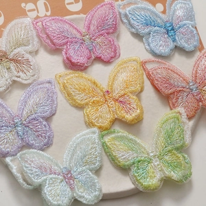 Détail de broderie papillon dégradée multicolore avec texture en mesh fin