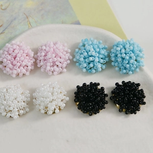 Handmade beaded flower earrings in macaron pink, blue, white and black on ceramic tray