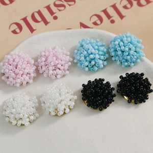 Macro shot of macaron beaded flower clusters with gold metal bases for DIY jewelry crafts