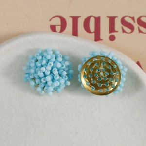 Detailed view of light blue beaded flower studs with golden metal base and fixing holes