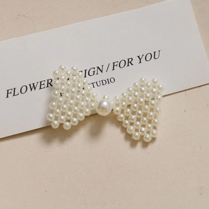 Barrette élégante en perles blanches tressées en forme de nœud avec perle centrale ronde