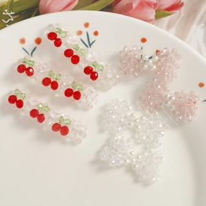 Vue détaillée de barrettes perlées faites main avec motifs cerise et nœuds roses