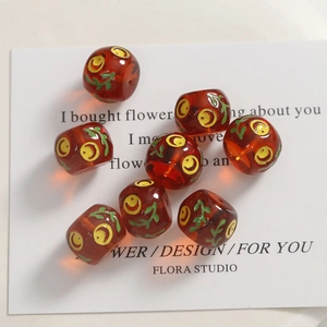 DIY amber resin beads with yellow smiley face and green leaf designs for jewelry
