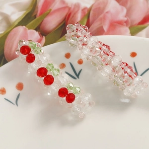 Détail de barrettes à cheveux faites main avec motifs cerises et perles de verre