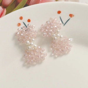 Détail de barrettes à nœuds faits main avec perles en verre rose et perles blanches