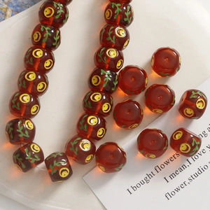 Detailed macro view of 14mm translucent brown resin beads with painted smile and leaf motifs