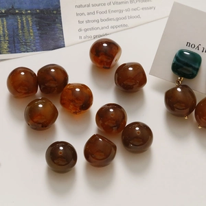 Artistic amber-colored resin beads with deep marbling for DIY jewelry making