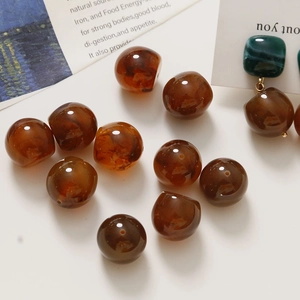 Artistic shot of amber resin beads with marble texture and completed drop earrings