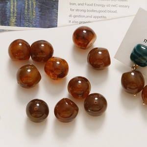 Macro shot of amber irregular resin beads with translucent caramel marble texture