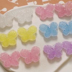 Macro shot of sugar-textured resin butterflies in pastel colors for DIY crafts and decor