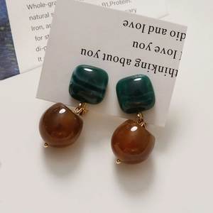 Detailed close-up of vintage resin clip earrings with marble green and amber brown finish
