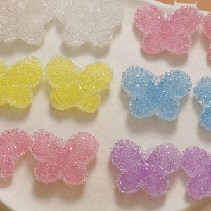 Macro shot of colorful resin butterfly charms with sugar diamond texture for DIY crafts