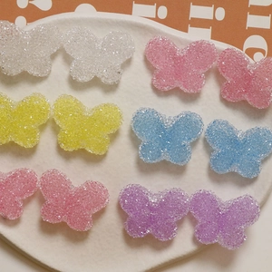 Detailed view of colorful butterfly resin charms with sugar texture for DIY crafts