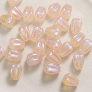 Macro view of pastel pink tulip beads with iridescent finish and vertical ribbed textures