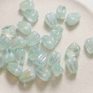 Detail shot of light green iridescent acrylic tulip flower beads for DIY jewelry making